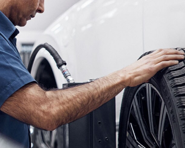 Técnico especializado Volvo revisando el neumático de un auto.