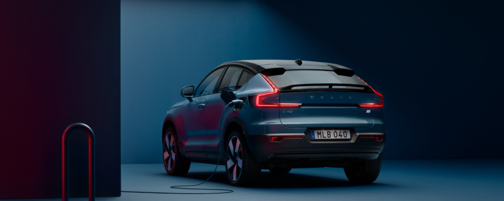 Vista trasera de vehículo eléctrico Volvo EC40 Pure Electric color azul Fjord con luces de neón