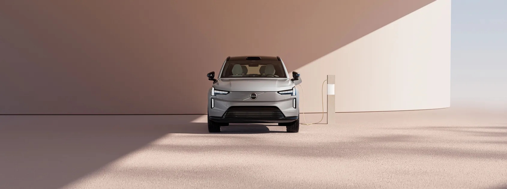 SUV Eléctrico Volvo EX90 color beige conectado a estación de carga.