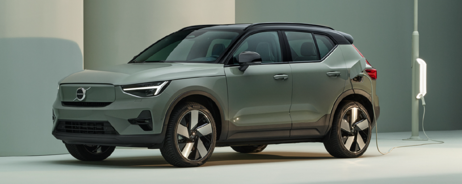 Volvo EX40 Electric color verde oliva siendo cargado conectado a una estación.