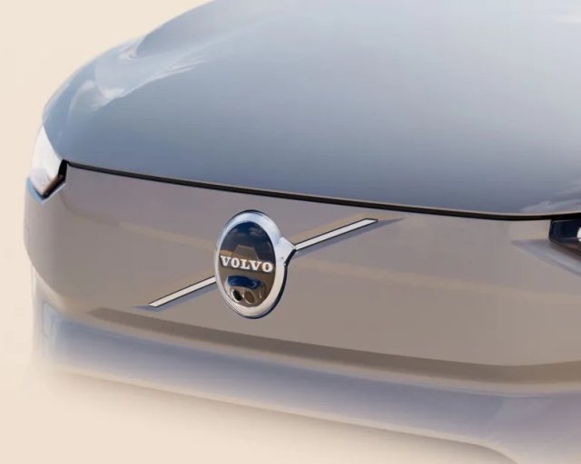 Vista frontal del capo de SUV eléctrico Volvo EX90 color gris con luces futuristas.