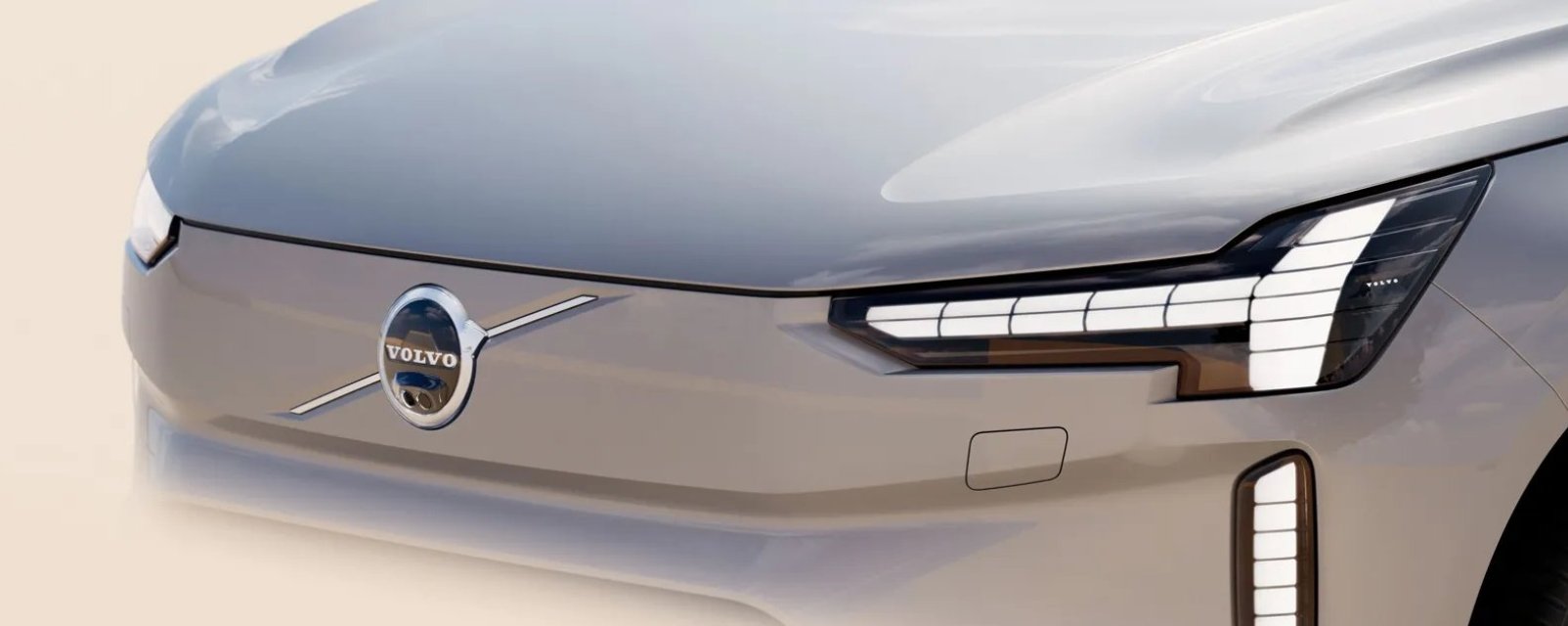 Vista frontal del capo de SUV eléctrico Volvo EX90 color gris con luces futuristas.